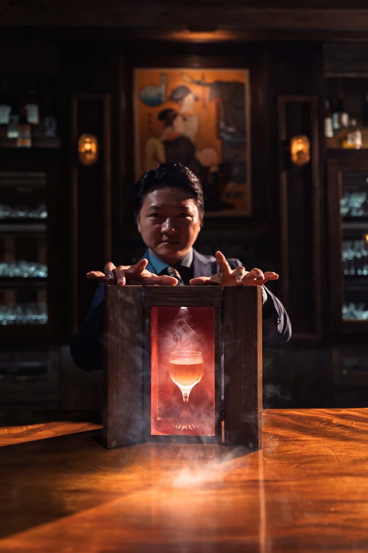 A man with a box with a glass in it and smoke.