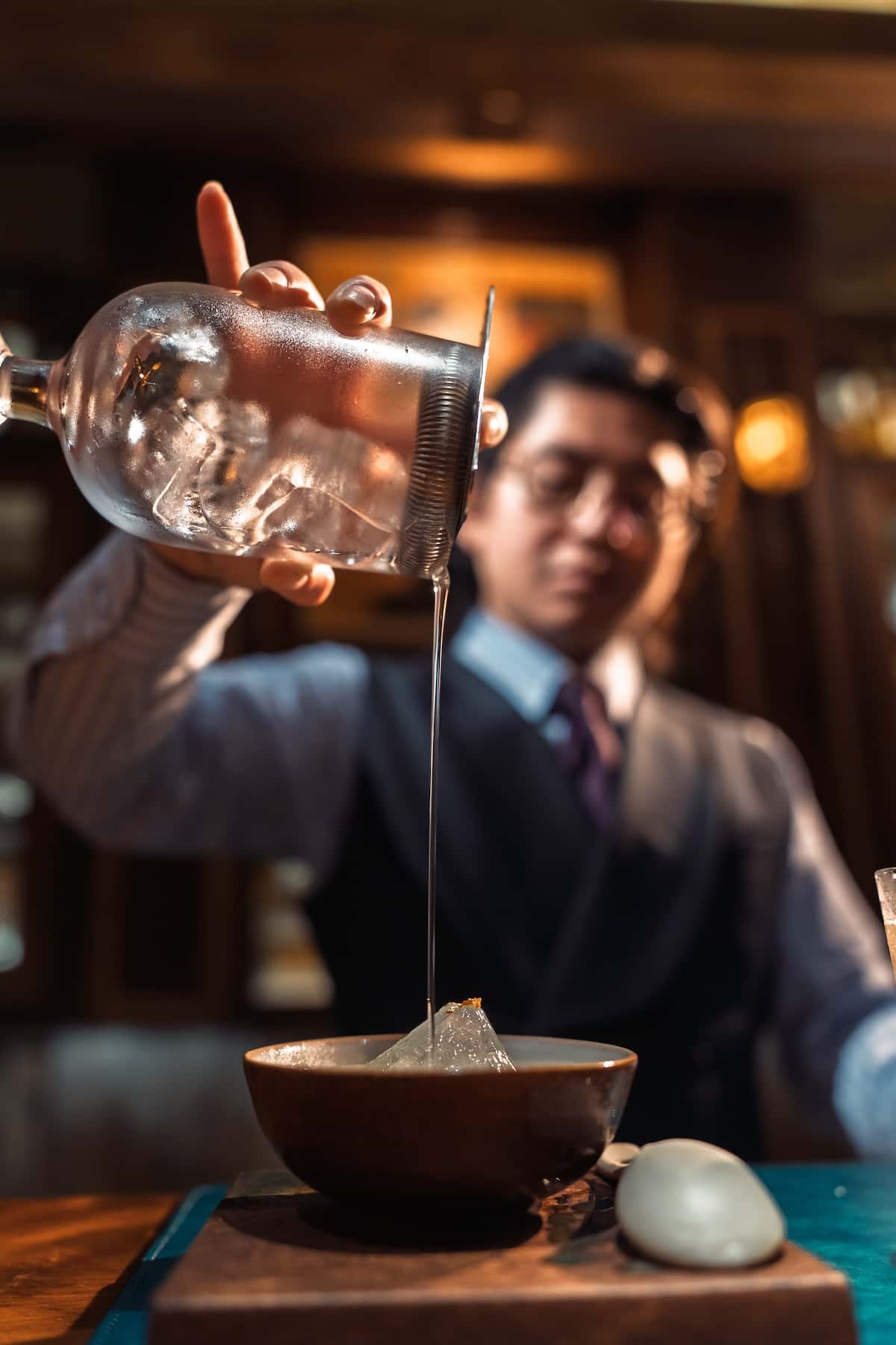 a person pouring ice into a glass