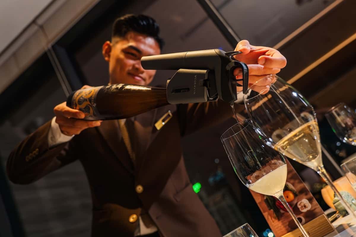 a man pouring wine into glasses