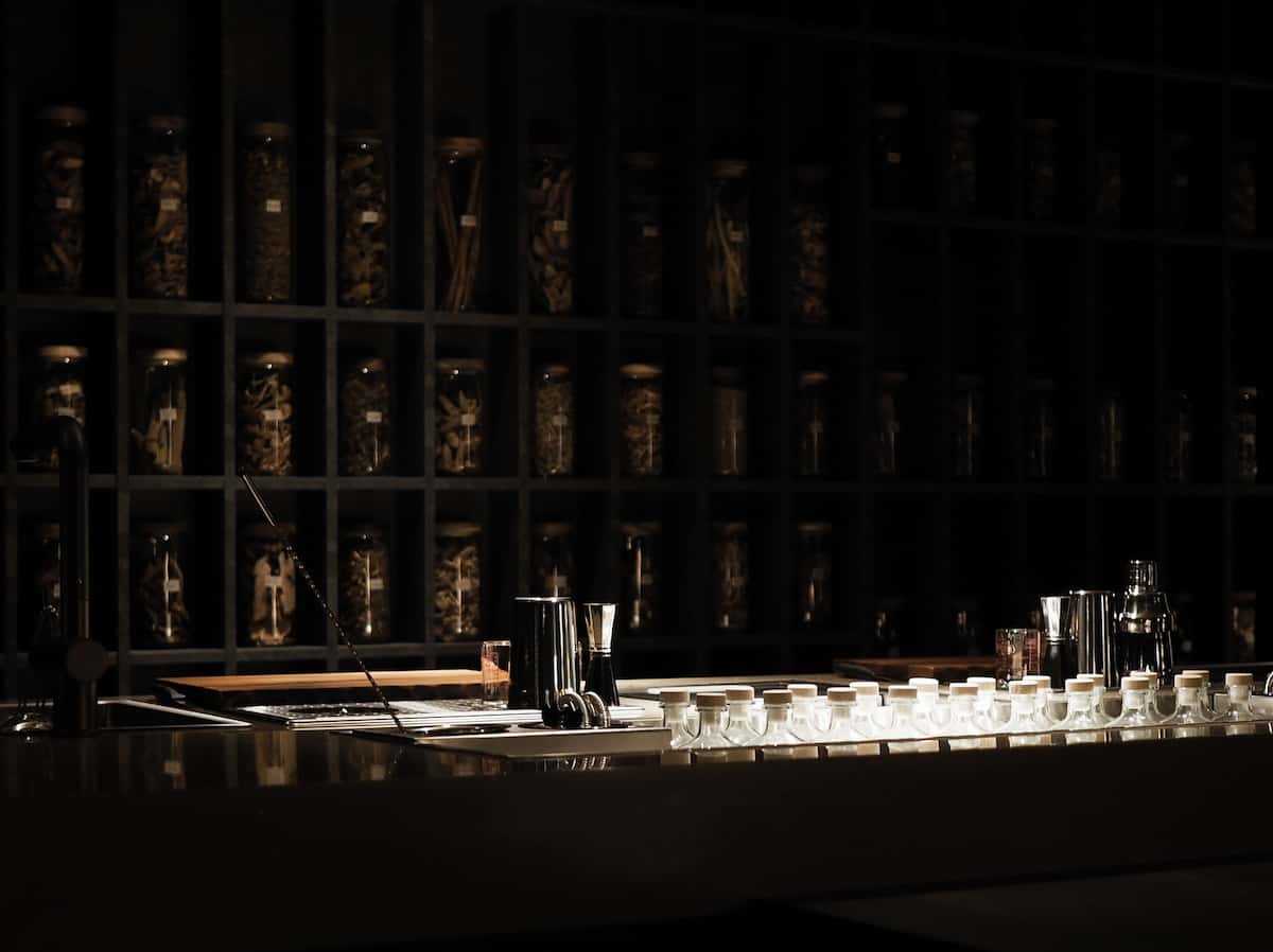 A dark bar with bottles and ingredients.
