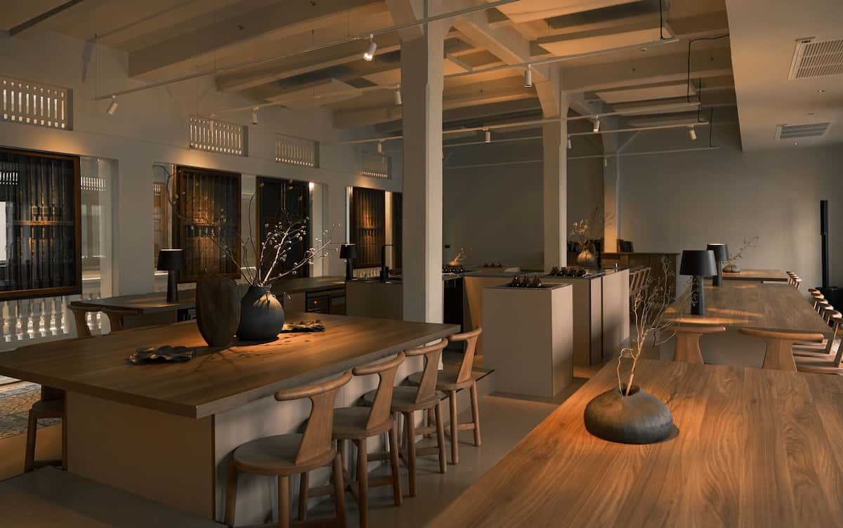 A bar with wooden tables and concrete walls and features.