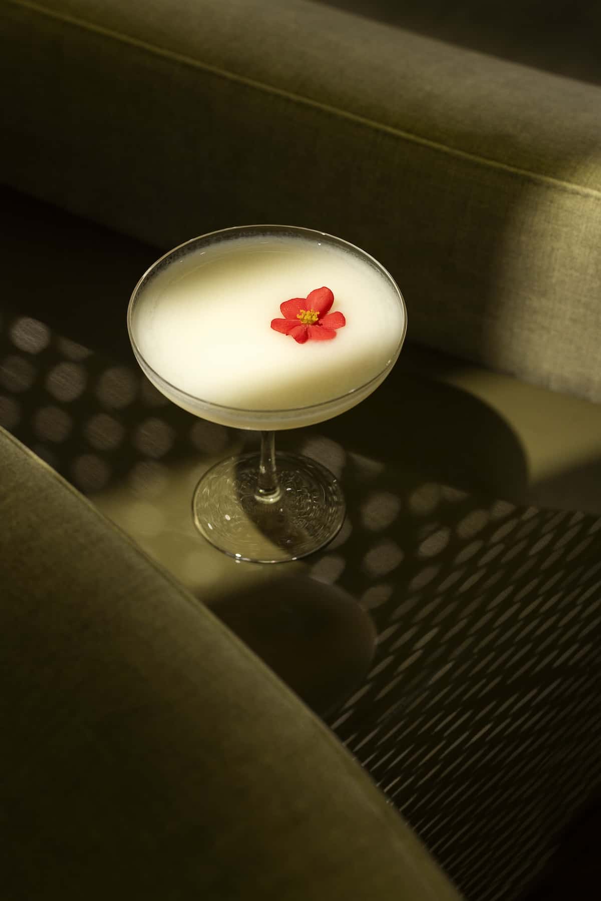 A creamy cocktail with a red flower.