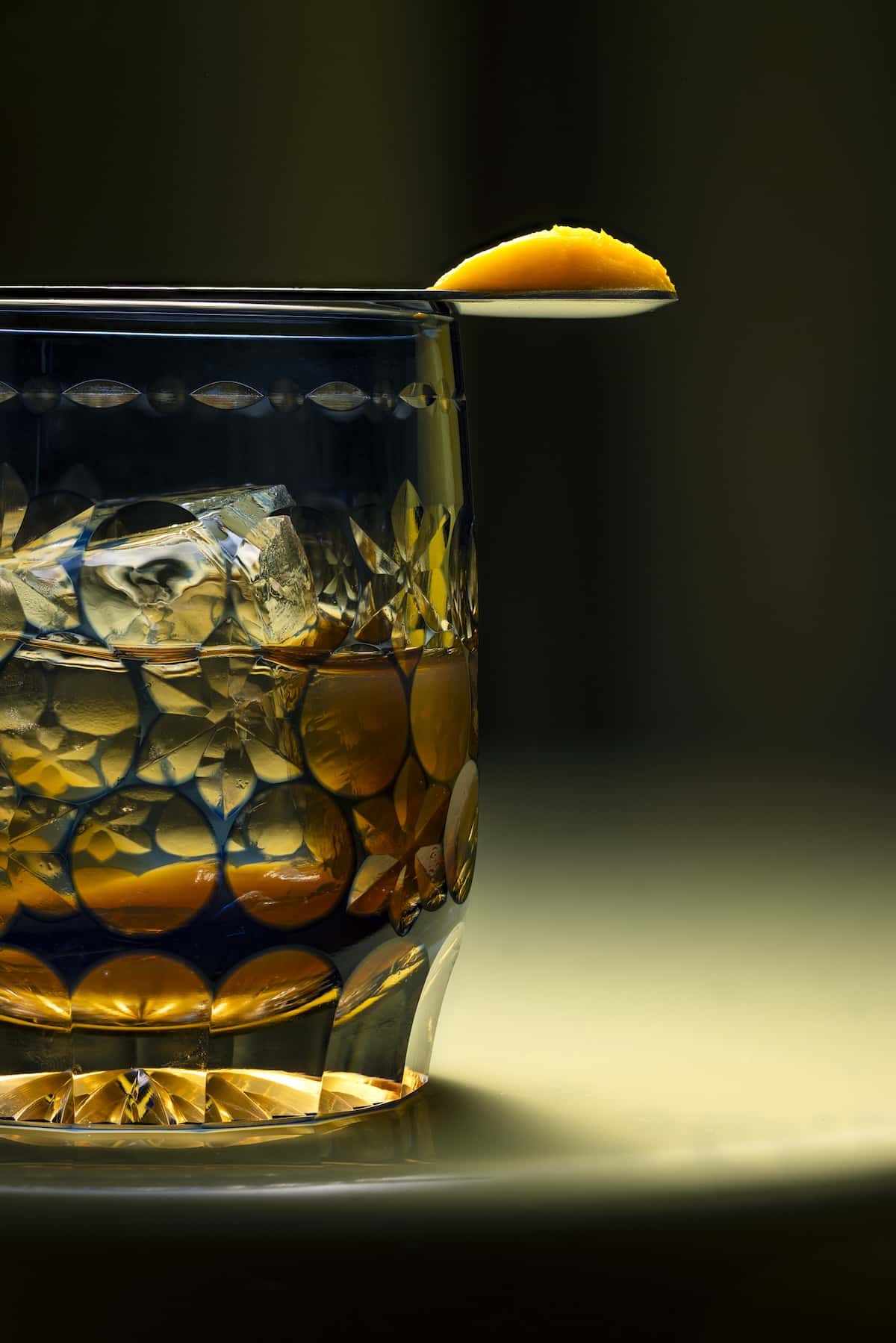 A drink with a spoon on top containing a yellow substance.