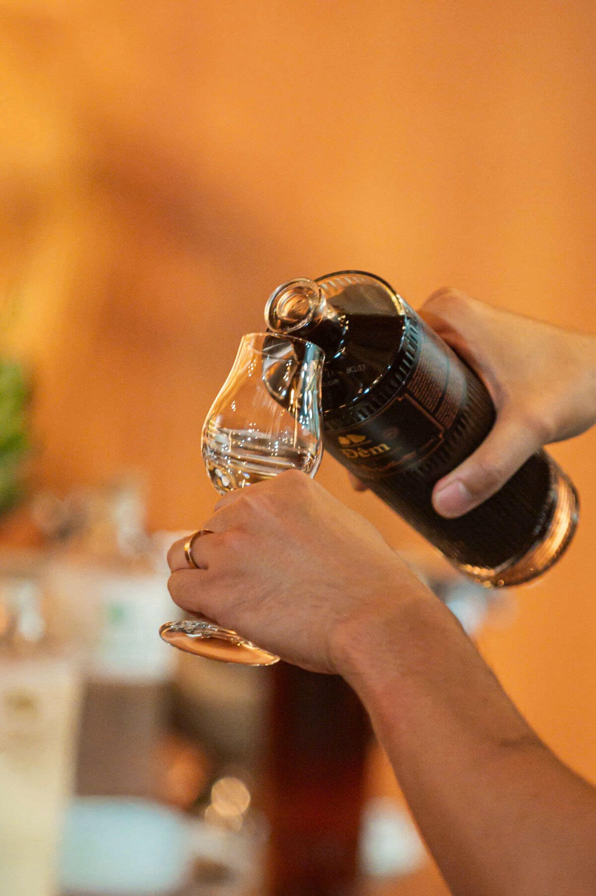 Pouring dark liquid into a glass.