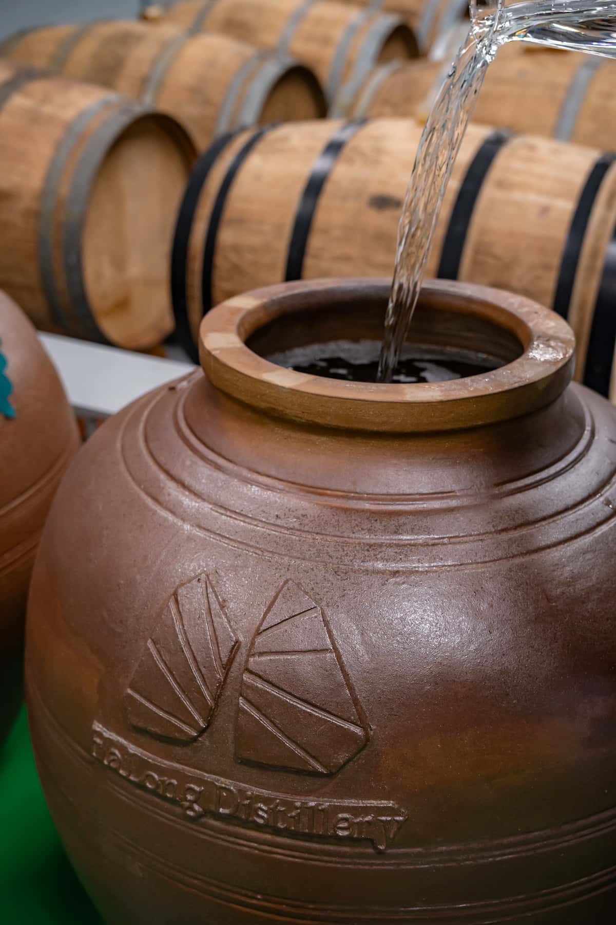 Pouring a liquid into a large clay pot.