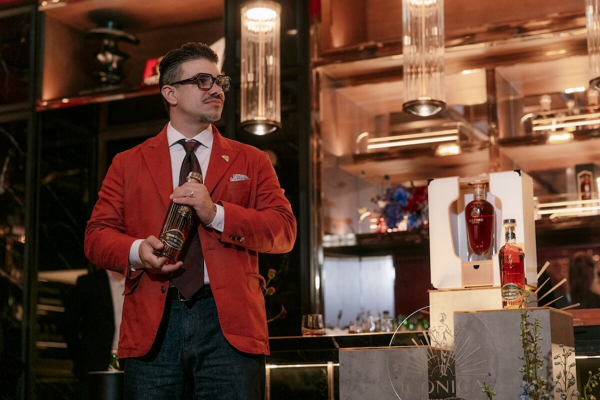 a man in a red suit holding a bottle