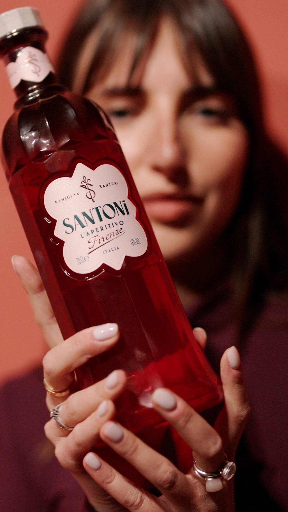 A woman with a bottle of red liquid.