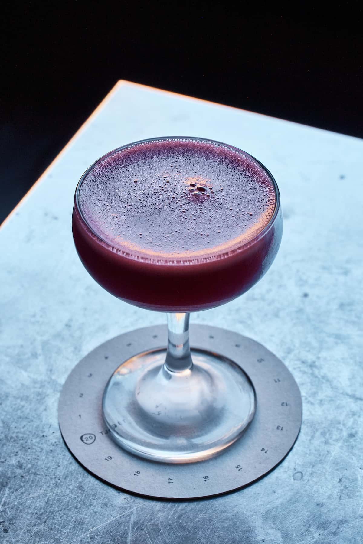 a glass with a drink on a coaster
