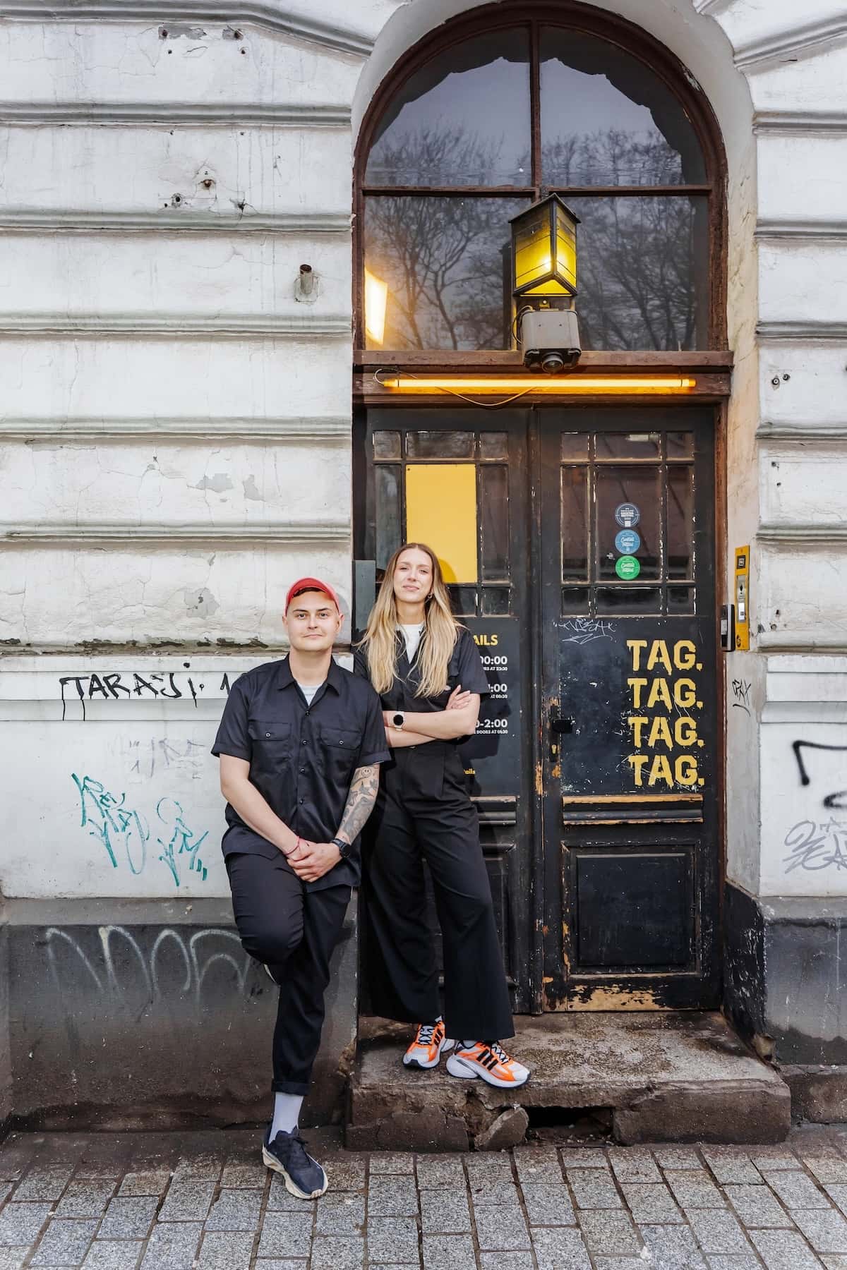 a man and woman standing in front of a building