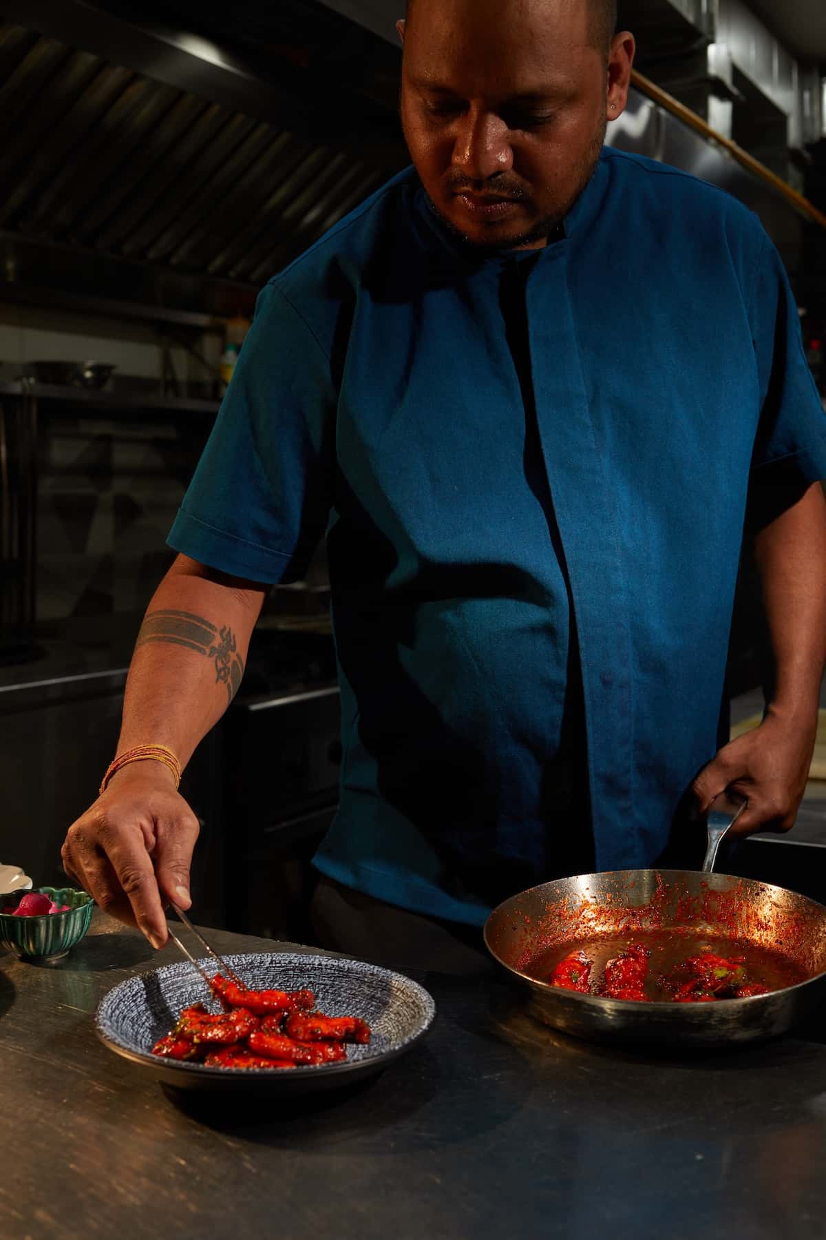 A chef with pans in the kitchen.