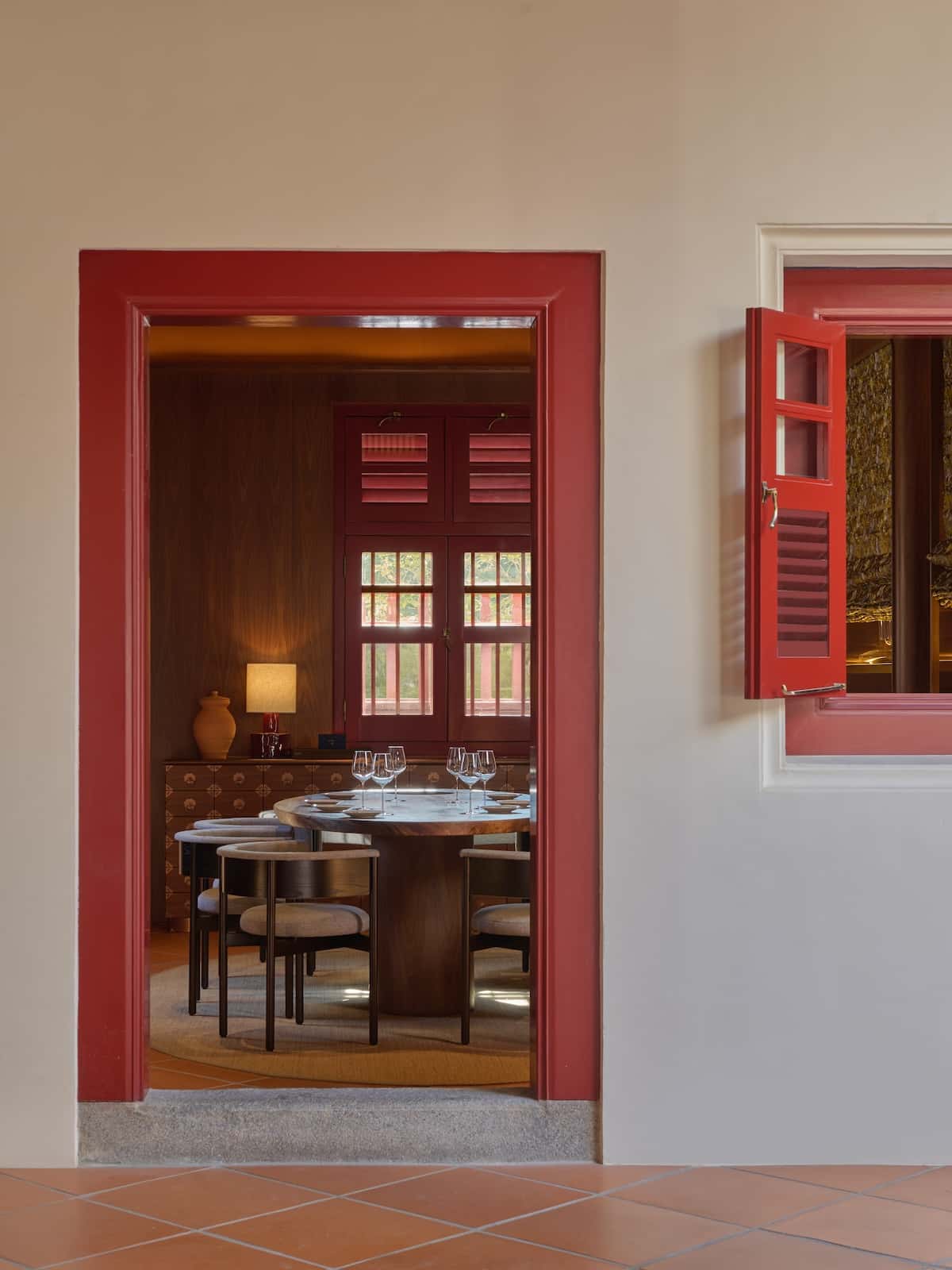 A red framed door and a dining room inside